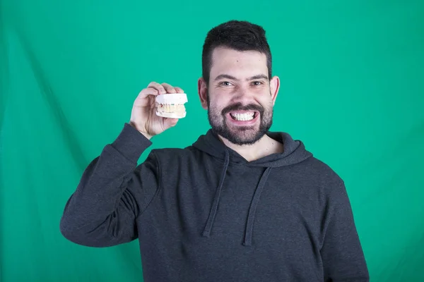 Retrato Hombre Feliz Contra Fondo Verde Sosteniendo Modelo Prótesis Dentales —  Fotos de Stock