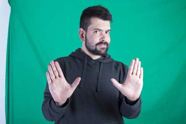 Hombre Con Capucha Posando Sobre Fondo Verde Haciendo Gestos Con —  Fotos de Stock