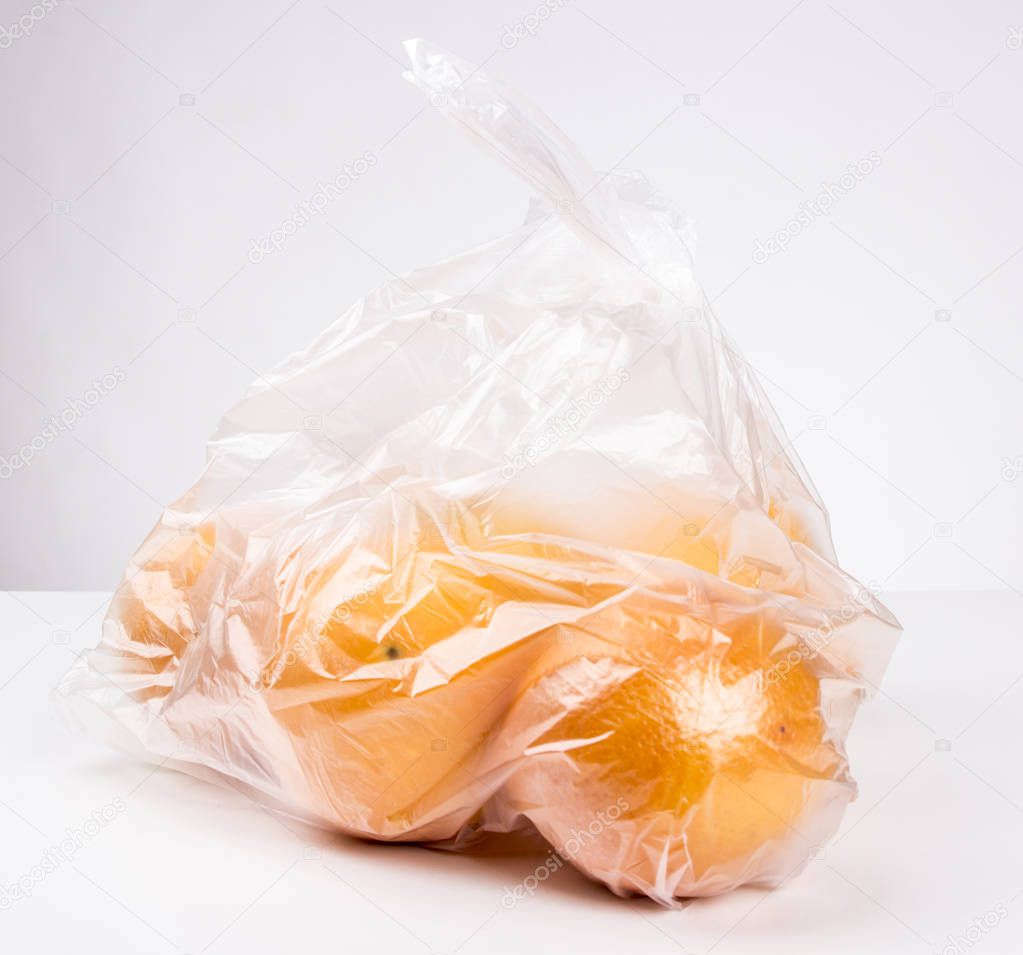 round orange fruits in plastic bag, studio shot