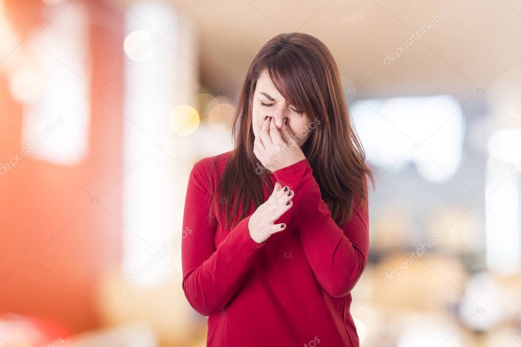 woman covering nose with hand, pinching nose