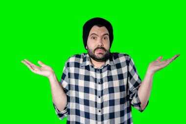 Yeşil stüdyo arka planında izole edilmiş, sıkılmış, bitkin ve hayal kırıklığına uğramış, çaresiz ve üzgün görünen genç bir adamın yakın plan fotoğrafı. Sorunlarla karşı karşıya.