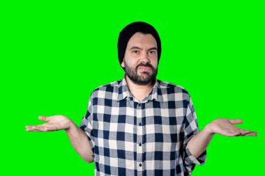 Yeşil stüdyo arka planında izole edilmiş, sıkılmış, bitkin ve hayal kırıklığına uğramış, çaresiz ve üzgün görünen genç bir adamın yakın plan fotoğrafı. Sorunlarla karşı karşıya.