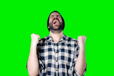 Neşeli genç bir adamın portresi iyi görünüyor ve zafer jesti krom arka planda izole edilmiş.