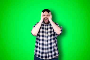 Kafası karışık sakallı bir adamın portresi. Krom arka planda izole bir şekilde el ele tutuşuyor.