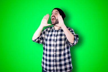 Çığlıklar, nefret, öfke. Kroma stüdyosunun arka planında ağlayan duygusal sinirli bir adam. Duygusal ve genç bir yüz. Yarım boy erkek portresi. İnsani duygular, yüz ifadesi kavramı