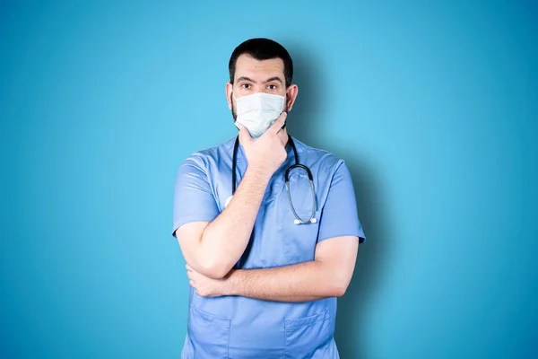 Schöner Arzt Mit Maske Auf Blauem Hintergrund Der Beim Nachschlagen Stockbild