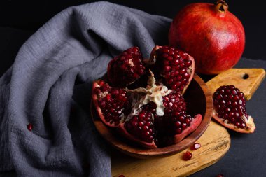 Olgun kırmızı sağlam ve kesme nar ahşap tahta ve koyu arka plan