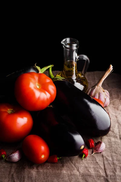 Contrast van sappig fruit: rode tomaten en aubergines — Stockfoto