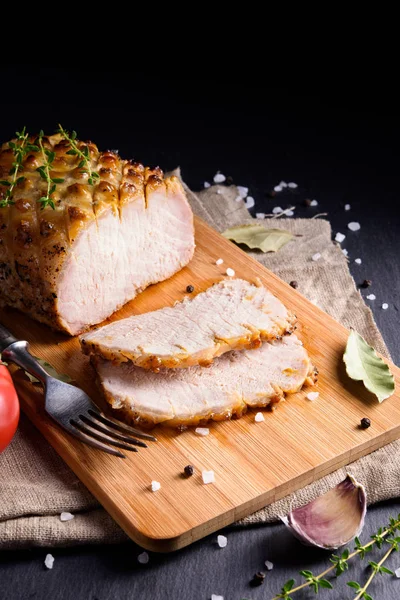 Gebratenes und in Scheiben geschnittenes Schweinefilet mit Honig und Senf auf Holzschneidebrett glasiert Stockfoto