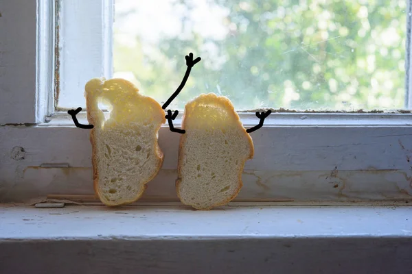 Zwei Brotscheiben auf der rustikalen Dorffensterbank Stockbild