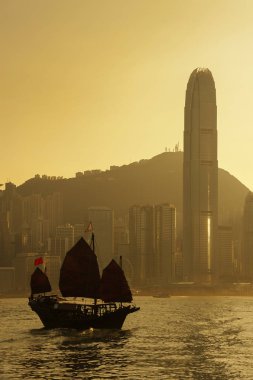 Yelkenli tekne Victoria harbor Hong Kong şehir günbatımı altında