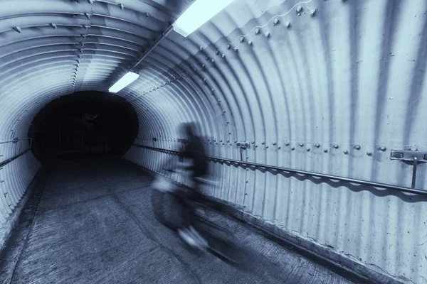 biker riding on bicycle in tunnel