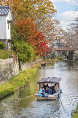 Omi Hachiman, Japan - November 24, 2018 : Japanese-style boat takes tourist around Hachiman-bori canal in Omihachiman, Japan clipart