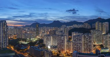 Hong Kong şehrinin manzarası gökyüzü ve Lion Rock tepesi alacakaranlıkta.