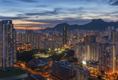 Hong Kong şehrinin manzarası gökyüzü ve Lion Rock tepesi alacakaranlıkta.