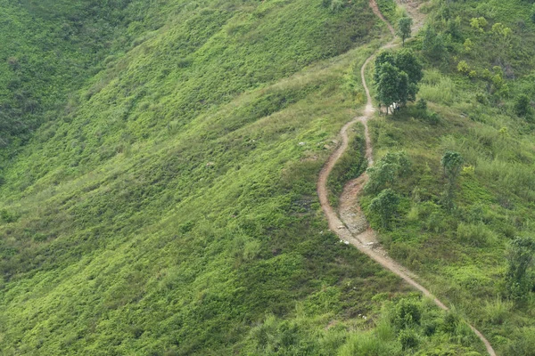 A long and winding rural path crosses the hill