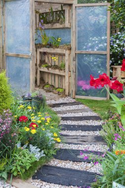 Küçük yeşil evde arka bahçesinde çiçek bahçesi