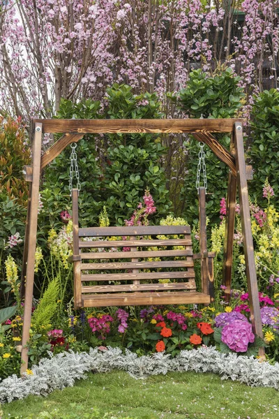 Columpio asiento en jardín de flores patio trasero —  Fotos de Stock