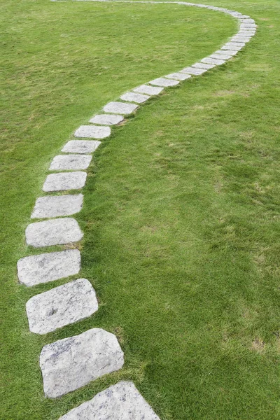 Stenvägen på grönt gräs. Naturlig bakgrund — Stockfoto