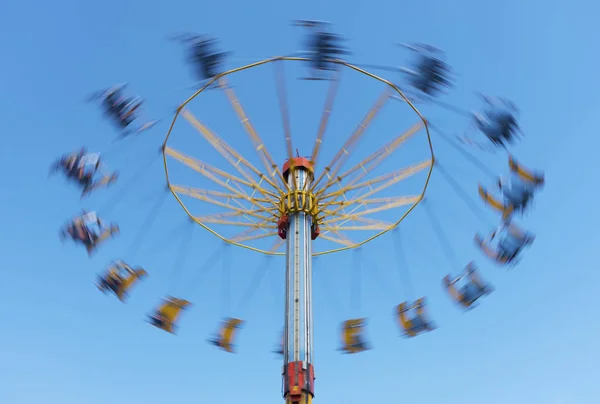 Karusell i rörelse i temapark med blå himmel bakgrund — Stockfoto