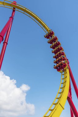 Lunaparkta mavi gökyüzü altında Rollercoaster yolculuğu