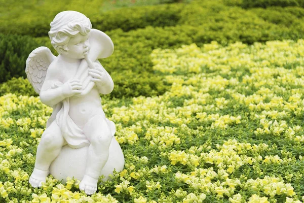 Scultura di angelo in giardino colorato fiore — Foto Stock