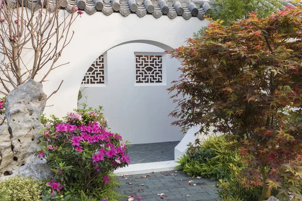 A Moon Gate is a circular opening in a garden wall that acts as