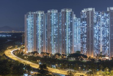 Geceleri Hong Kong şehrinde yüksek binalar ve otoyollar.