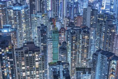 Geceleri Hong Kong şehrinde kalabalık bir gökdelen manzarası.