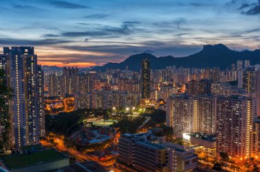Hong Kong şehrinin manzarası gökyüzü ve Lion Rock tepesi alacakaranlıkta.