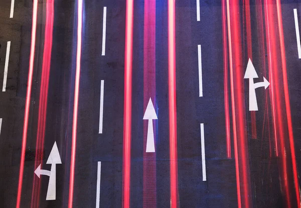 Gece trafiği. Siyah asfalta beyaz ok işareti