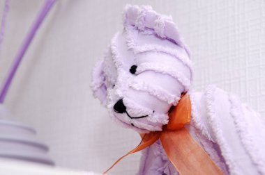 Menekşe peluş oyuncak ayı kahverengi bir yay ile.