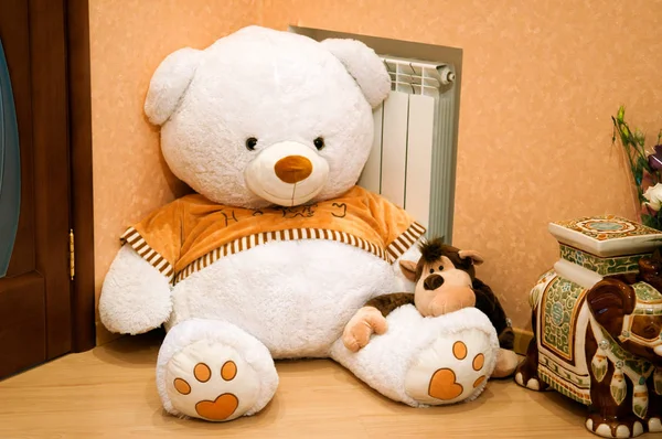 A large plush white bear and a toy brown monkey.