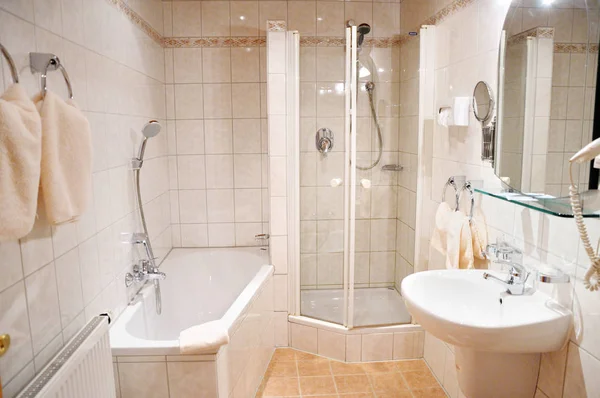 ホテルの部屋に美しい広々 とした明るいバスルーム 明るいタイル 白いお風呂 シャワー シンク 化粧品ミラー タオル — ストック写真