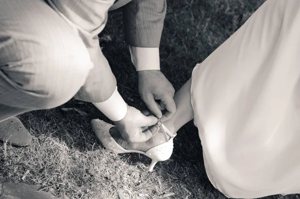 男は女性の靴にベルトを締める — ストック写真