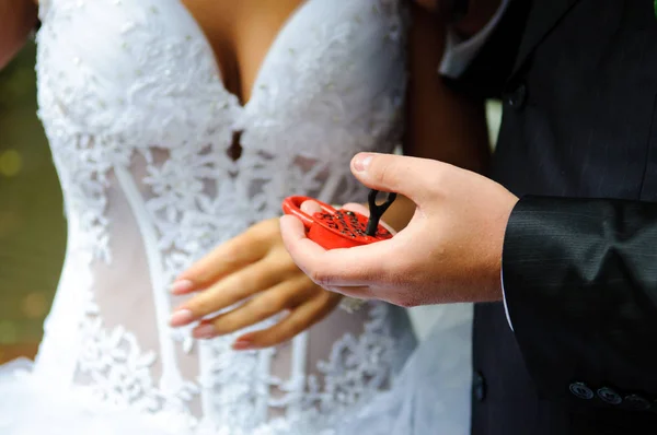 Mãos Noiva Noivo Mantêm Fechadura Vermelha Forma Coração Recém Casados — Fotografia de Stock