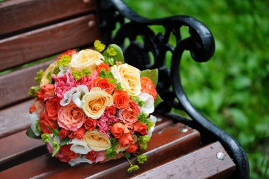 Güzel bir dövme bankta gelin buketi. Rengarenk çiçekler buket düğün.