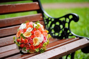 Güzel bir dövme bankta gelin buketi. Rengarenk çiçekler buket düğün.