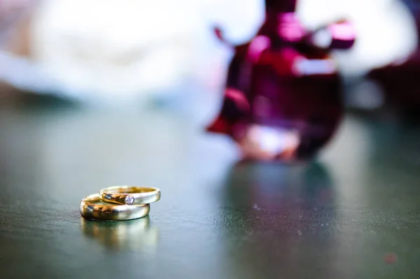 Esküvő Gyűrű Háttérben Egy Lila Parfümös Üveg — Stock Fotó