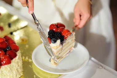 Yeni evli bir parça düğün pastası kesti taze çilek ile dekore edilmiştir..