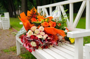 Güzel Park beyaz bir bankta gül demetleri.