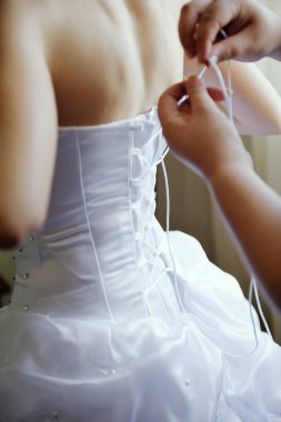 Sabah gelin hazırlanması. Kadınların elleri bir şerit bir gelinlik korse üzerinde kravat..