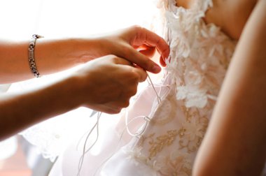 Sabah gelin hazırlanması. Kadınların elleri bir şerit bir gelinlik korse üzerinde kravat..