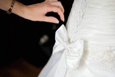 Sabah gelin hazırlanması. Kadınların elleri bir şerit Pruvadan düğün elbise kravat..