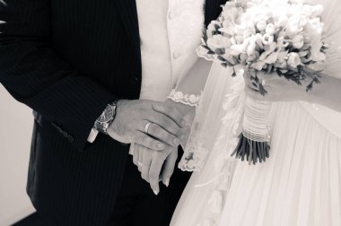 Gelin ve damat parkta yürüyüş sırasında elele tutuşun. Düğün günü yazın. Siyah ve beyaz.