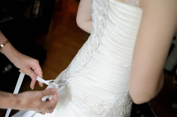 朝の花嫁の支度 女性の手は ウェディング ドレスのコルセットにリボンを結ぶ — ストック写真