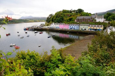 Portree liman renkli evleri ve tekneler Bay, ağaçlar ön planda. Isle of Skye, İskoçya.