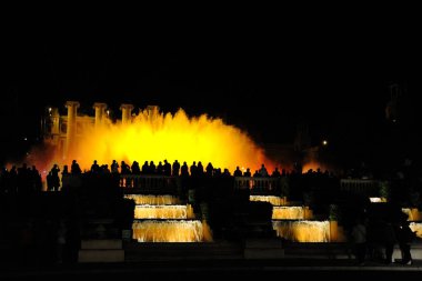 Barcelona, İspanya Ulusal Müzesi yanındaki geceleri güzel çeşme ışık gösterisi. Gece, insanlar büyük bir parlayan Çeşmede arıyoruz. Çeşme ana hatlarını insan figürleri ve bir arka plan üzerinde.