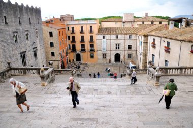 Girona, İspanya 29 Mayıs 2014: Turist Girona katedralde merdivenleri tırmanmaya. Roma Katolik Kilisesi ve taht oyunları çekim 6 sezon yeri. Meydanın giriş görünümünü.