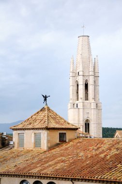 Katedral Meydanı'na Basilica de Sant Feliu (Kilise St. Felix) görünümü. Ön planda bir rüzgar gülü ile döşenmiş bir çatı. Girona, İspanya.